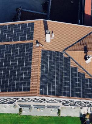 Sicht aus der Vogelperspektive auf die Photovoltaikplatten auf dem Dach des Rosenalp Gesundheitsresort & Spa.