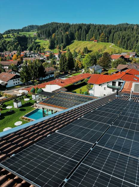 Sicht von oben auf das Rosenalp Gesundheitsresort & Spa mit seinen Solarpanelen auf dem Dach.