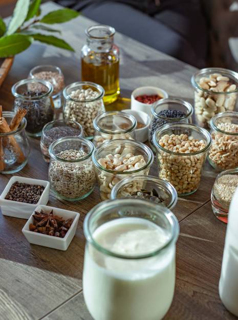 Diverse natürliche Lebensmittel in Glasbehältern auf einem Tisch.