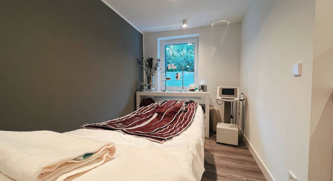 Ein Behandlungszimmer mit Liege und medizinischen Gerät als Ort für Medical Wellness im Allgäu.