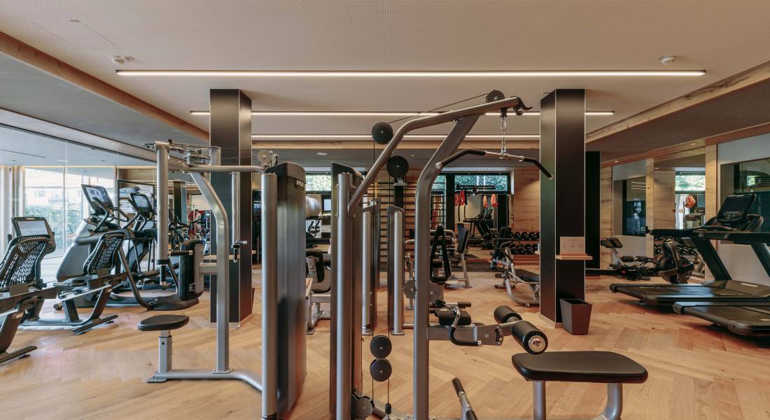 Einblick in den Fitnessraum der Rosenalp. Erkennbar ist eine großzügige Trainingsfläche mit unterschiedlichsten Fitnessgeräten.