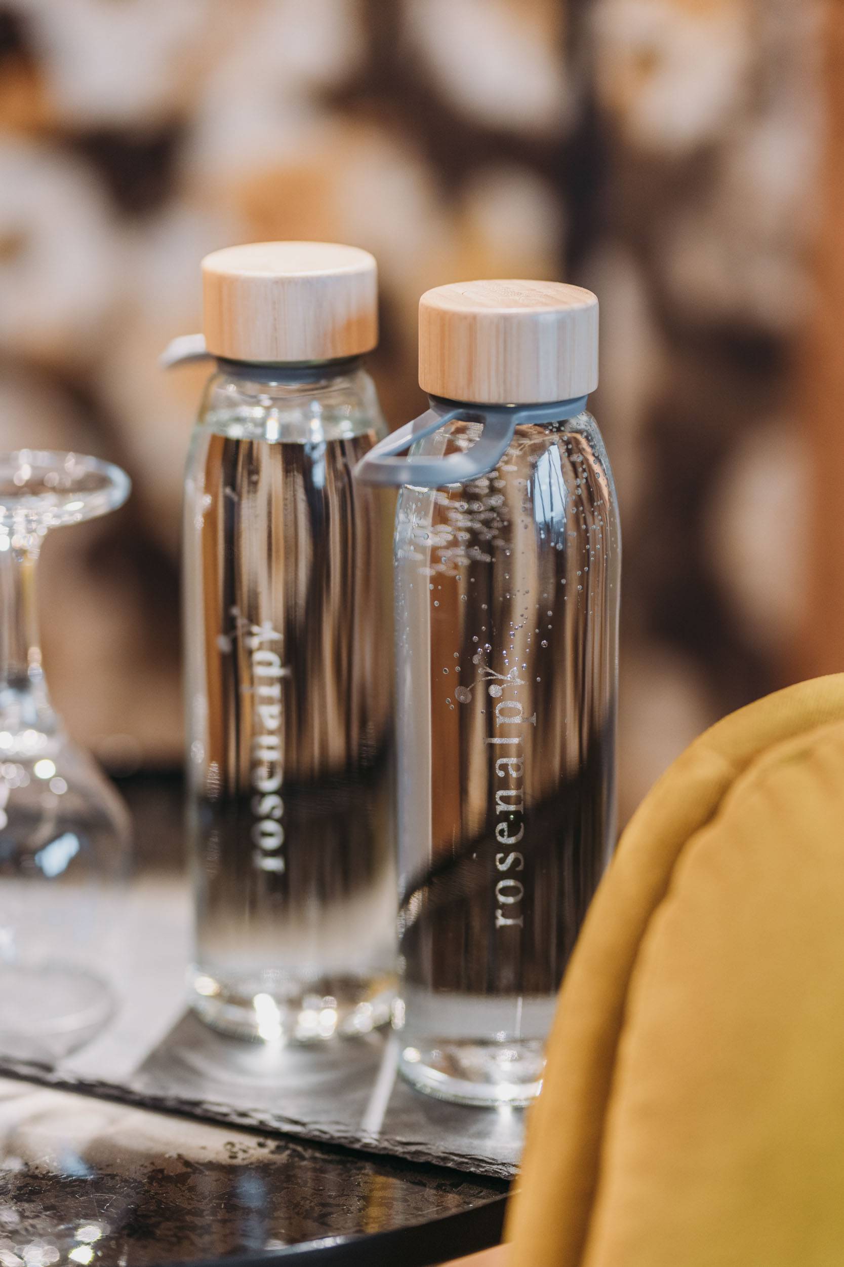 Zwei Glasflaschen mit Holzverschluss und der Aufschrift "rosenalp"