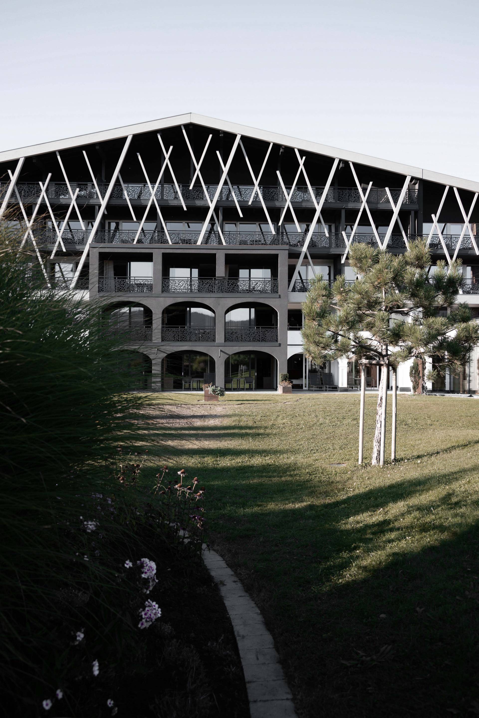 Außenansicht auf das Rosenalp Gesundheitsresort & Spa mit Wiese im Vordergrund.