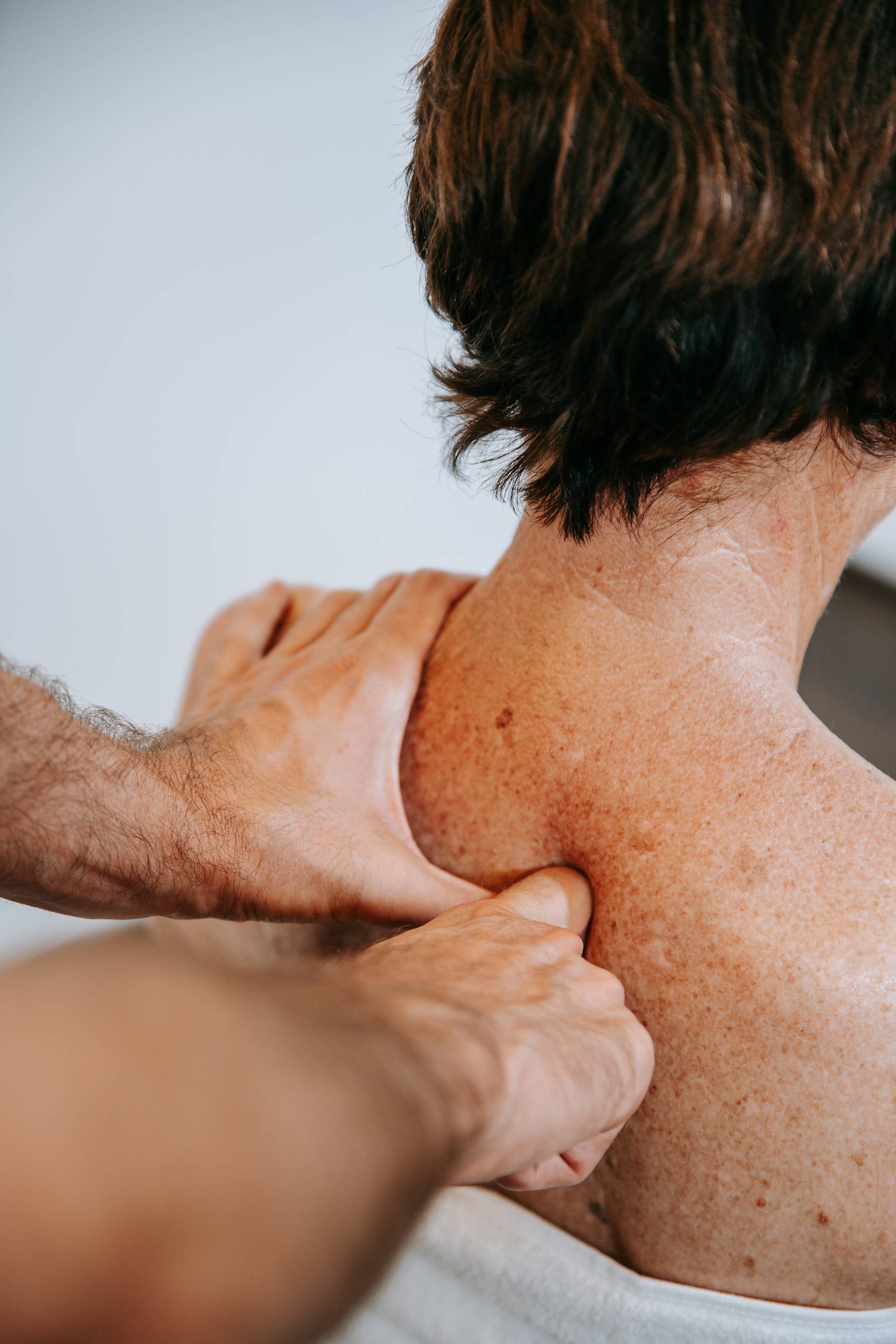 Frau bekommt eine physiotherapeutische Behandlung des oberen Rücken.