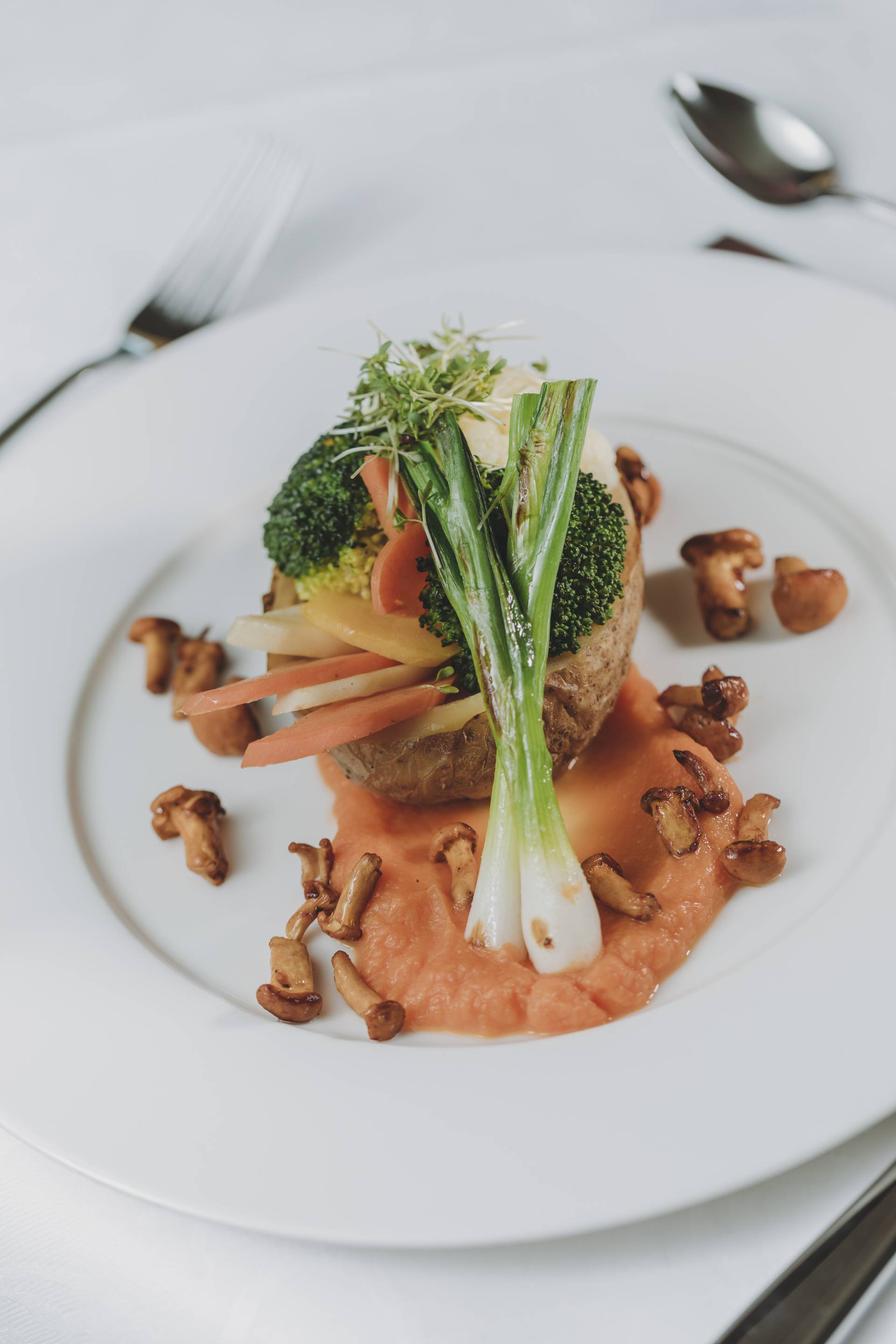 Ein Gericht mit unterschiedlichen Gemüsesorten ist ansehnlich auf einem weißen Teller platziert.