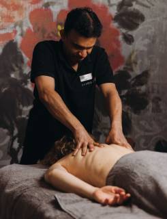 Verschiedene Wellnessprodukte für Massagen sind auf einem Handtuch platziert.