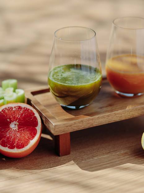 Zwei Gläser mit Säften mit unterschiedlichem Obst und Gemüse dekoriert, welches Teil des Heilfasten in Oberstaufen ist.
