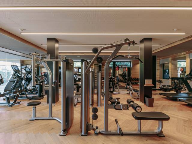 Einblick in den Fitnessraum der Rosenalp. Erkennbar ist eine großzügige Trainingsfläche mit unterschiedlichsten Fitnessgeräten.