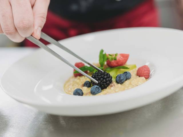 Nahaufnahme vom Anrichten eines ansehnlichen Frühstücktellers mit verschiedenen Früchten.