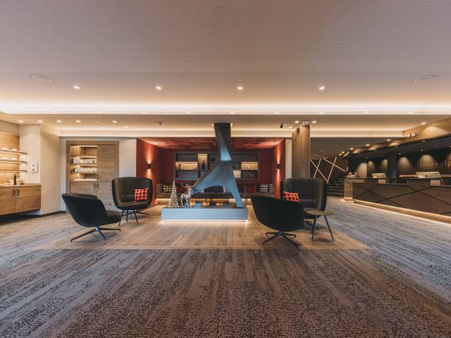 Sicht auf die moderne Rezeption des Rosenalp Gesundheitsresort & Spa mit Sitzgelegenheiten und gemütlicher Beleuchtung.
