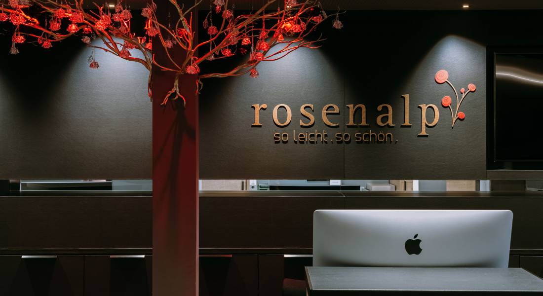 Logo des Rosenalp Gesundheitsresort & Spa an einer Wand der Rezeption.