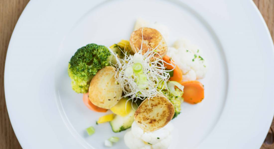 Buntes Gemüse ist auf einem weißen Teller platziert als Teil des Kururlaub in Bayern.