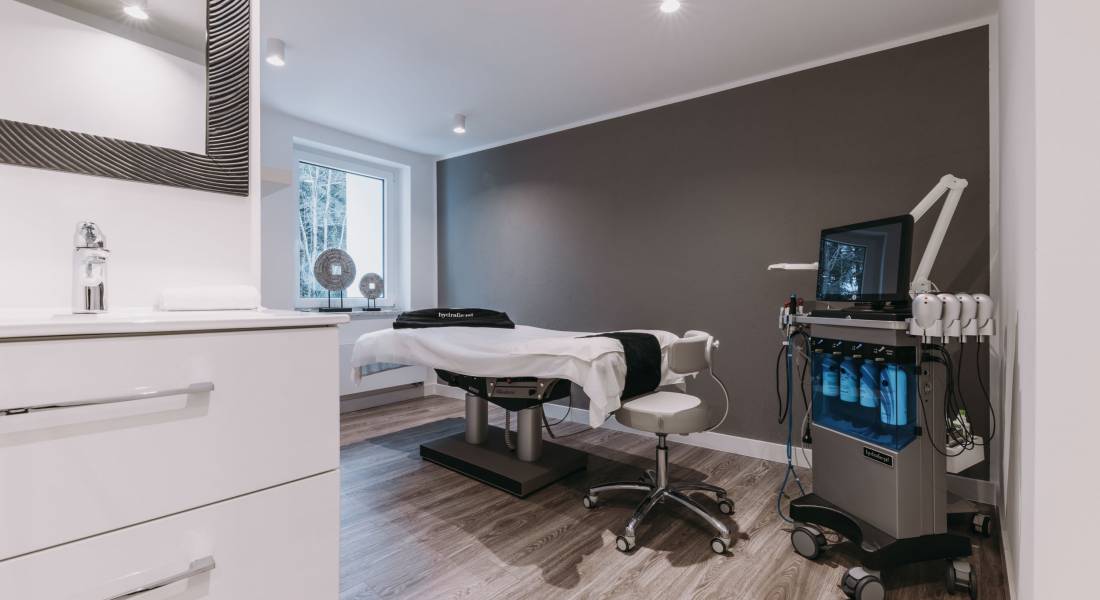 Ein modern eingerichteter Praxisraum mit medizinischem Gerät und einer elektronischen Behandlungsliege.