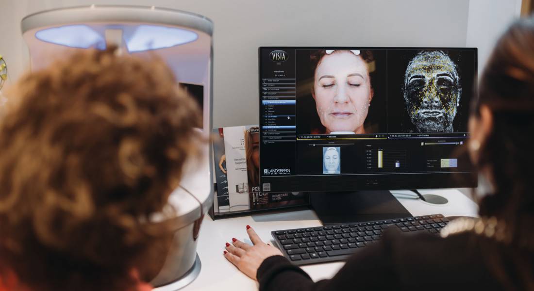 Zwei Frauen betrachten eine medizinische Darstellung auf einem Monitor.