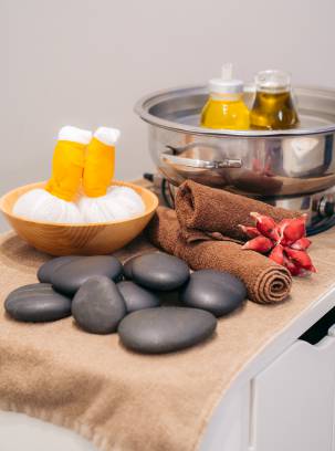 Verschiedene Wellnessprodukte für Massagen sind auf einem Handtuch platziert.