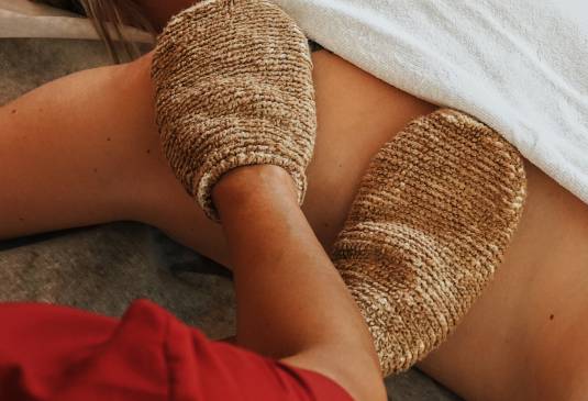 Frau erhält Rückenbehandlung mit Massagehandschuhen als Teil des Wellness in Oberstaufen.