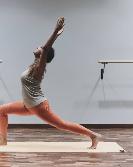 Eine Frau macht Yoga auf einer Gymnastikmatte in einem modernen Studio.