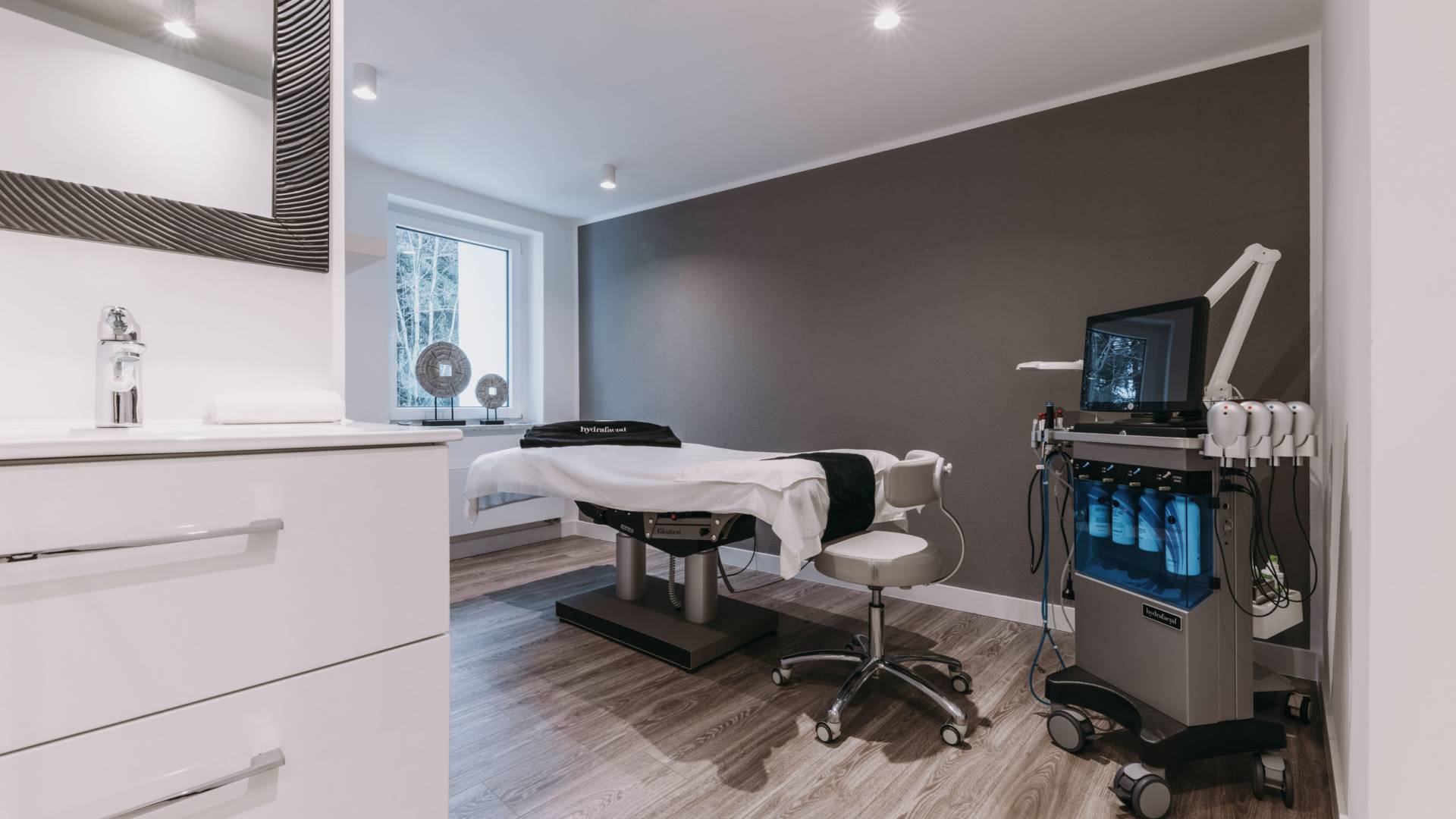 Ein modern eingerichteter Praxisraum mit medizinischem Gerät und einer elektronischen Behandlungsliege.