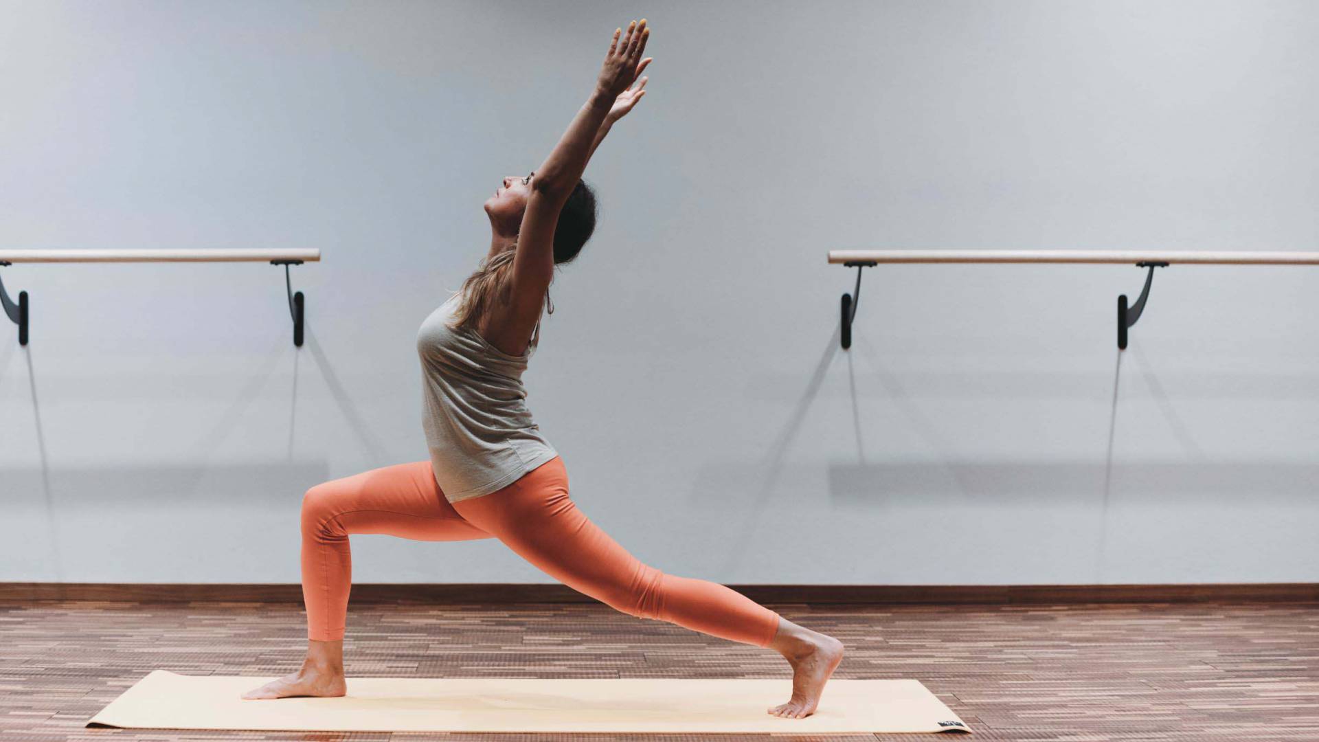 Eine Frau in auffälliger Sporthose macht Yoga in einem Studio als Teil ihres Aktivurlaub im Allgäu.